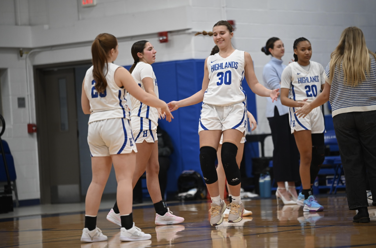 Avery Barber (11) jogs and high fives her teammates after the announcer calls her name in the starting five before the game. 